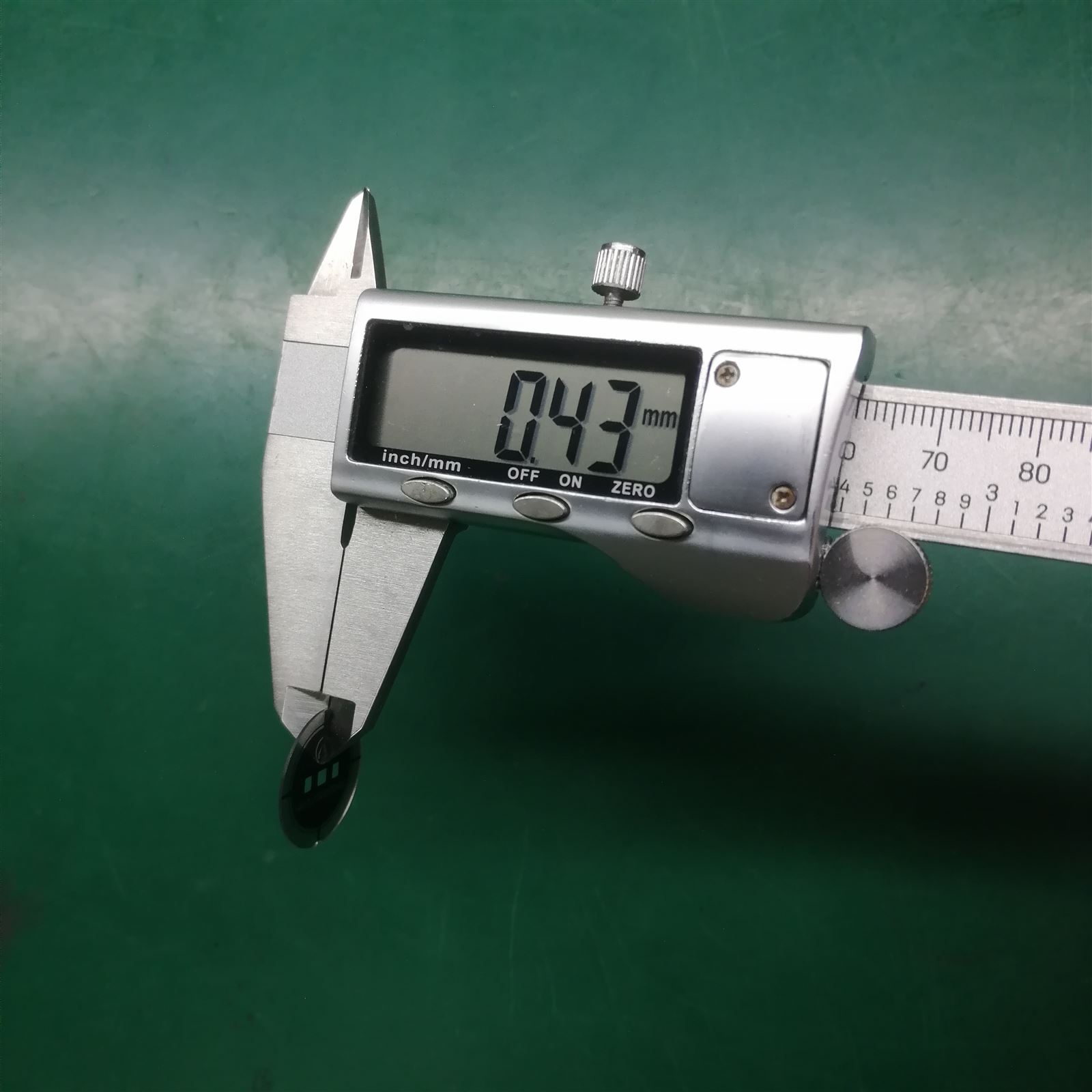 EngraSun factory — digital caliper measuring a watch lens