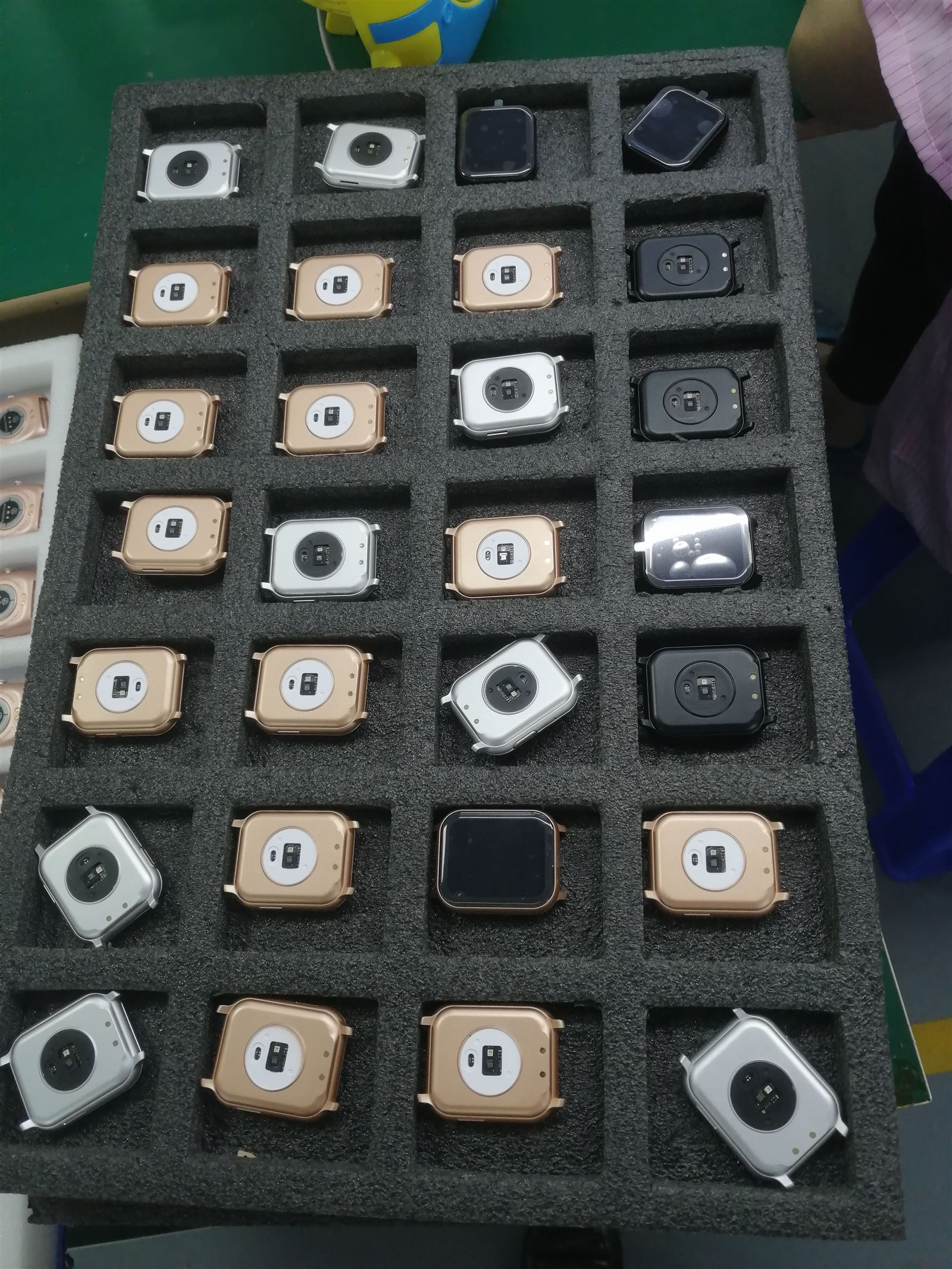 EngraSun factory — tray of multi-colour watch bodies